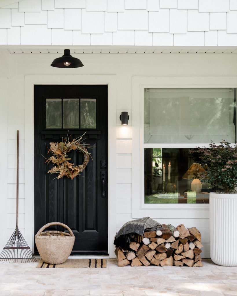 Entryway with a black door decorated for autumn