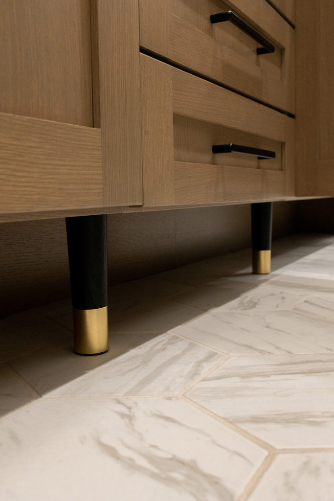 Exposed feet with brass details under the cabinet really dress up the space