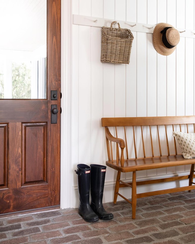 Peg rail in Traditional styled Entry way with Wood bench and black boots